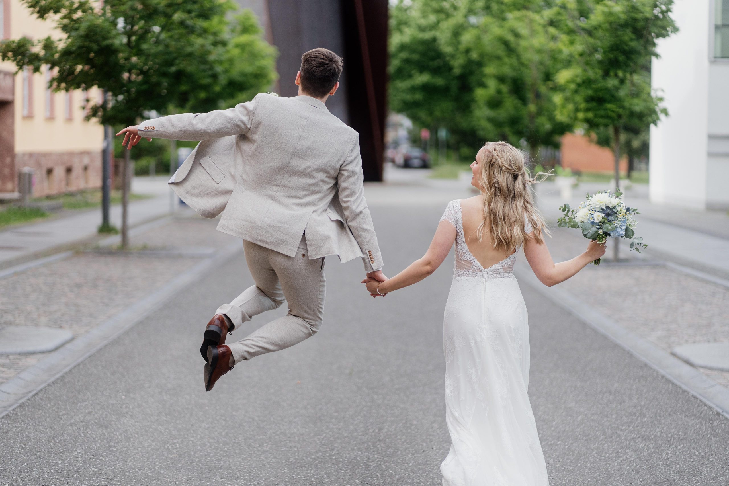 Braeutigam springt in die Luft und haelt Frau an der Hand - Hochzeitsplanung Darmstadt & Rhein-Main