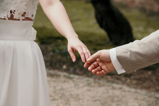 Brautpaar berührt sich an den Händen