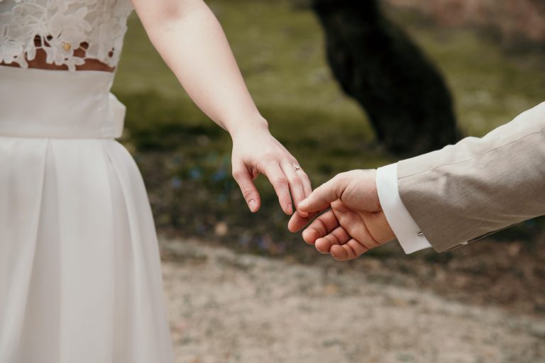 Brautpaar berührt sich an den Händen