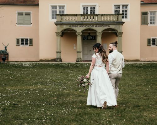 Brautpaar Jagdschloss Kranichstein Brautpaar läuft alleine über eine grüne Wiese, im Hintergrund ein Museum
