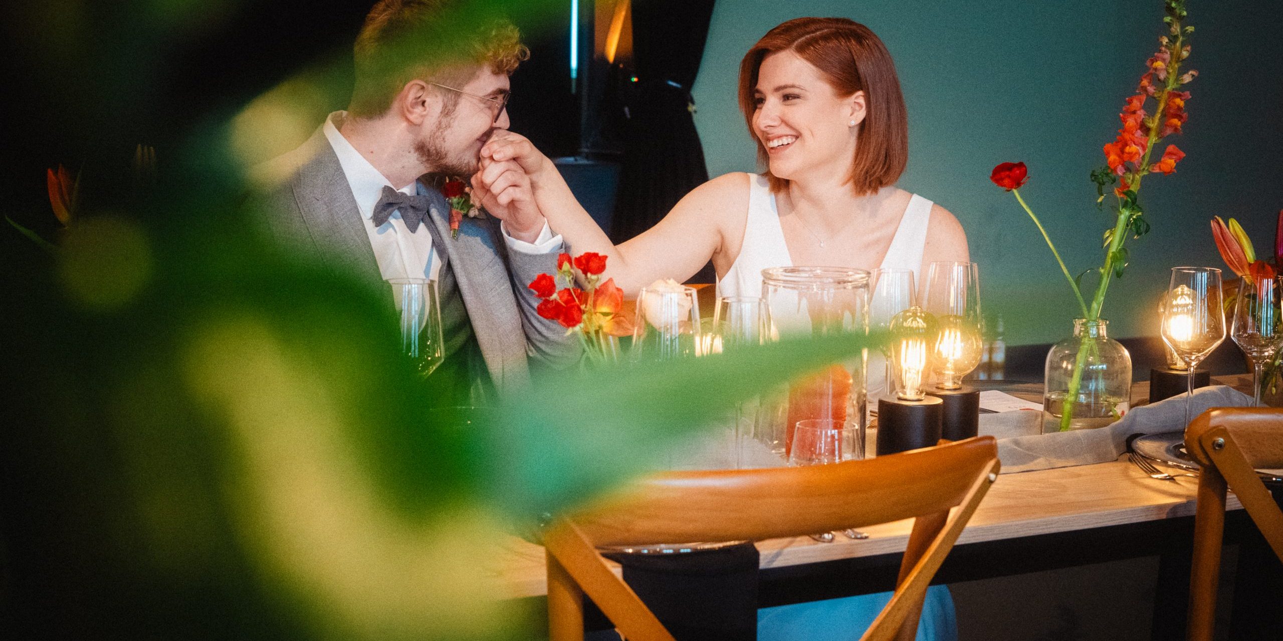 DSC04483 Brautpaar am Tisch, er küsst ihre Hand