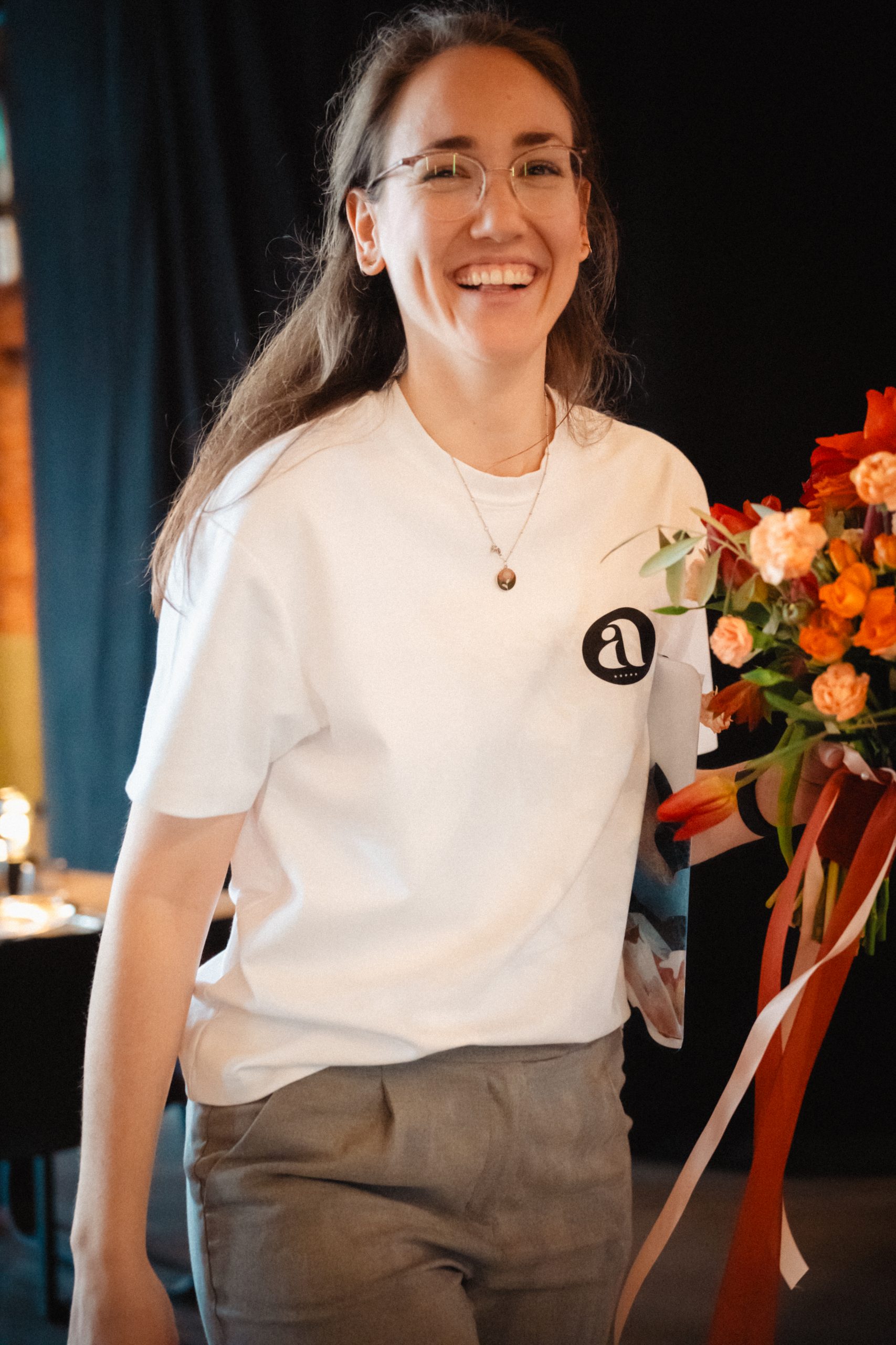 Alina mit Brautstrauß lachende Hochzeitsplanerin mit Brautstrauß in der Hand und Klemmbrett unter dem Arm