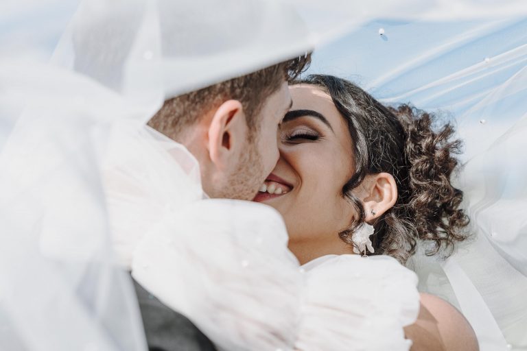 Brautpaar küsst sich unterm Schleier