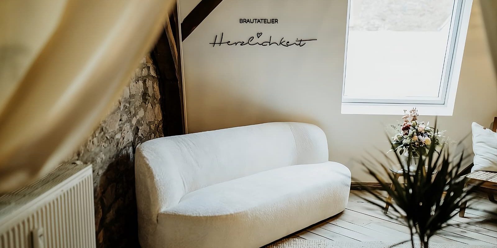 Brautatelier Herzlichkeit Couch und Logo von Brautatelier Herzlichkeit