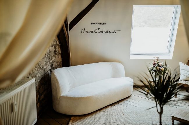 Brautatelier Herzlichkeit Couch und Logo von Brautatelier Herzlichkeit