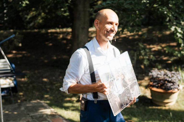 Andreas Fließgarten steht mit Bild im Garten