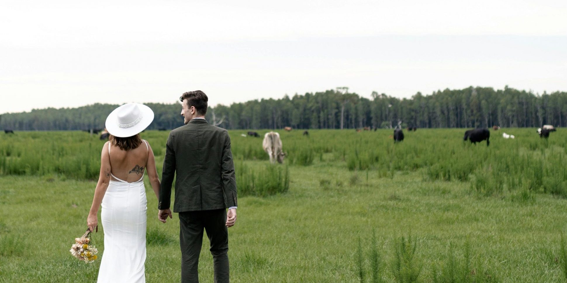 individuelle Hochzeitsplanung Brautpaar auf grüner Wiese, mit Kühen und Weitblick