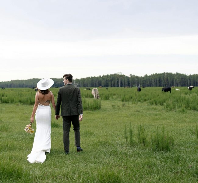 individuelle Hochzeitsplanung Brautpaar auf grüner Wiese, mit Kühen und Weitblick