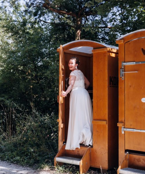 Braut geht auf die Trockentoilette von Kompotoi