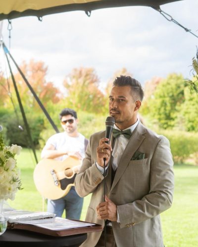 Redner steht an seinem Pult bei einer freien Trauung unter einem Stretch-Zelt