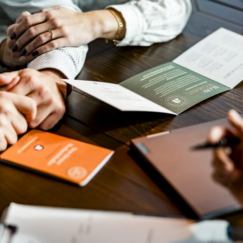 Hochzeitsplanerin Alina sitzt am Tisch und bespricht die Hochzeit mit einem Brautpaar