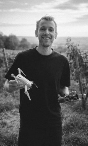 Lukas von luk(e)motion hält eine Drohne in der einen und die Fernbedienung in der anderen Hand