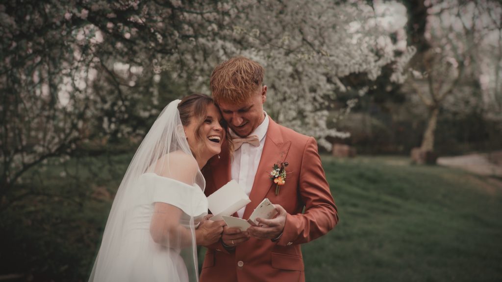 Lachendes Brautpaar beim Lesen ihrer Gelübte