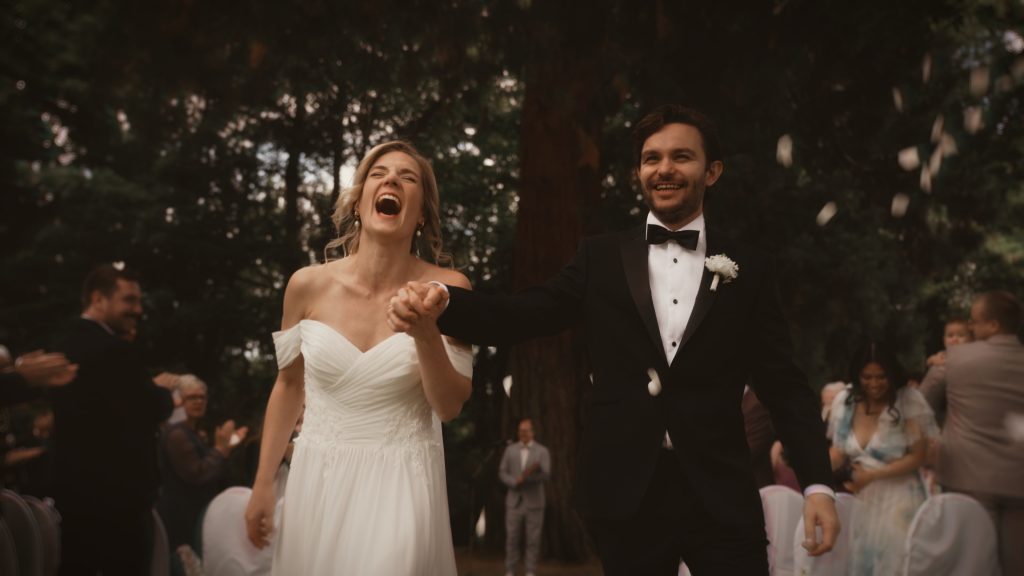 Lachendes Brautpaar beim Auszug nach der Trauung