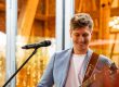 KILLI mit Gitarre vor einer Scheune