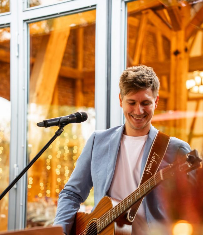 KILLI mit Gitarre vor einer Scheune