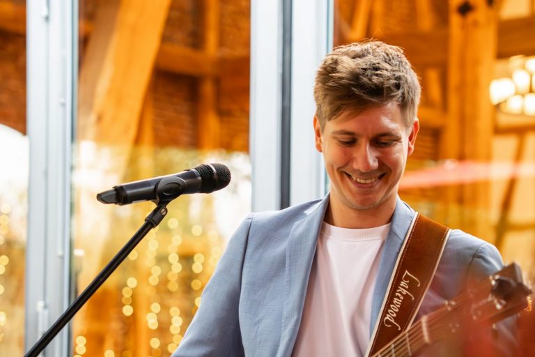 KILLI mit Gitarre vor einer Scheune